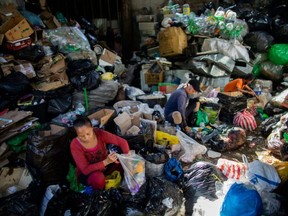 Workers sort through bags of garbage at a disposal facility in Payatas, Quezon City, Philippines, July 21, 2020.