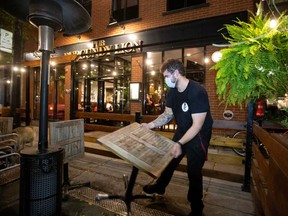 An employee dismantles the terrasse at closing time as the Quebec government has ordered all restaurants, bars and casinos to close for 28 days effective midnight Sept. 30 as COVID-19 numbers continue to rise in Montreal, Sept. 30, 2020.
