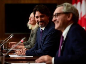 Prime Minister Justin Trudeau, shares a laugh with Minister of Infrastructure and Communities Catherine McKenna, left, and Chair of the Board of the Canada Infrastructure Bank Michael Sabia during a a press conference in Ottawa on Thursday, Oct. 1, 2020.