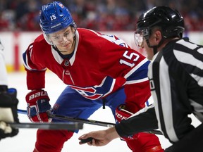 Canadiens Jesperi Kotkaniemi keeps his eye on the puck in linesman Travis Toomey's hand during faceoff against the San Jose Sharks in Montreal on Oct. 24, 2019.