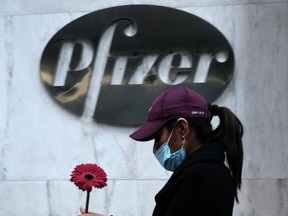A woman walks by Pfizer's New York headquarters as New York City tries to contain a spike in COVID-19 cases on November 16, 2020 in New York City.