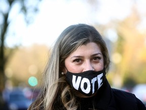A woman wears a mask with a sign "VOTE" on the day of the 2020 U.S. presidential election in Washington, U.S., Nov. 3, 2020.
