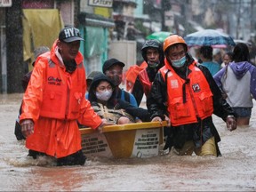 Residents affected by floods from Typhoon Vamco are rescued on a boat, at Marikina, Metro Manila, Philippines, Nov. 12, 2020.