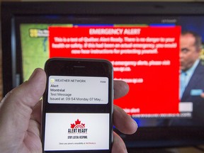 A smartphone and a television receive visual and audio alerts to test Alert Ready, a national public alert system, in Montreal on Monday, May 7, 2018.