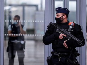 Belgian police officers stand guard at the entrance to Antwerp courthouse, on November 27, 2020.