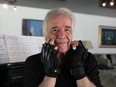 Brazilian conductor and pianist Joao Carlos Martins, 80, who after many years lost the ability to play due to health complications from focal dystonia, poses for a picture wearing bionic gloves at his house in Sao Paulo, Brazil, Oct. 28, 2020.