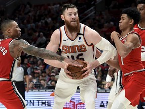 Aron Baynes (centre), drives between a pair of Portland Trail Blazers last season. Acquired by Toronto, Baynes is expected to be the Raptors' starting centre.