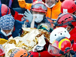 Elif Perincek, a three-year-old survivor, holds the thumb of a rescue worker as she is carried out of a collapsed building after an earthquake in the Aegean port city of Izmir, Turkey November 2, 2020.