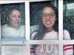 Lisa Ali and her 15-year-old daughter Tahlia look out from the front door of their Halifax-area home in Cole Harbour, N.S., on March 24, 2020.