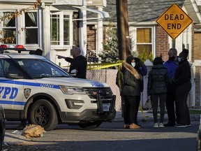 Police maintain a perimeter outside a crime scene, Tuesday, Nov. 24, 2020, in the Queens borough of New York.