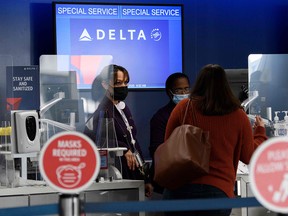 Passengers check bags for a Delta Air Lines flight during the Covid-19 pandemic at Los Angeles International Airport November 18, 2020.