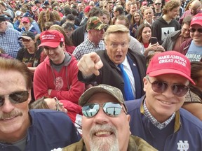 Donald Trump impersonator Donald Rosso (pointing) poses with fans at a 2019 Trump rally in Grand Rapids, Mich.