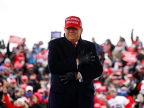 U.S. President Donald Trump reacts to cold weather and wind during a campaign rally at Michigan Sports Stars Park in Washington, Mich., Sunday, Nov. 1, 2020.