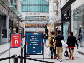 People walk in the Eaton Centre shopping mall in downtown Toronto as the Ontario government begins to allow stores to reopen following COVID-19 restrictions, June 24, 2020.