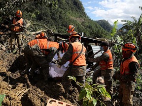 Soldiers recover a body from an area hit by a mudslide  as the search for victims continues in the buried village of Queja, Alta Verapaz, Guatemala November 8, 2020.