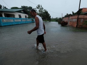 A man walks in a flooded street due to overflow of the river Lancetilla in Tela, Honduras, Tuesday, Nov. 3, 2020.