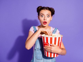 Close up photo beautiful amazing she her lady two buns watch tv show hold popcorn bucket eyes full fear mouth open wear casual t-shirt jeans denim overalls clothes isolated purple violet background