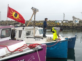 Indigenous fishermen adjust lines on their boat in Saulnierville, N.S. on Wednesday, Oct. 21, 2020.