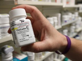 A pharmacist holds a bottle of OxyContin made by Purdue Pharma at a pharmacy in Provo, Utah, May 9, 2019.