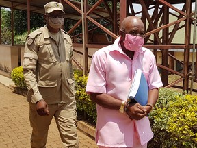 Paul Rusesabagina, portrayed as a hero in a movie about Rwanda's 1994 genocide, is escorted in handcuffs from the courtroom in Kigali, Rwanda September 25, 2020.