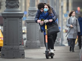 A couple ride a scooter in central Moscow on Nov. 5, 2020, amid the ongoing coronavirus disease pandemic.