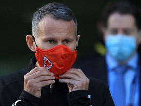 Wales' head coach Ryan Giggs adjusts his face covering, worn due to the COVID-19 pandemic, as he walks on the pitch ahead of the UEFA Nations League Group match against Ireland at the The Aviva Stadium in Dublin on October 11, 2020.