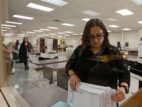 Eliza Luna, a ballot designer with the Maricopa County Elections Department, counts ballots for the Arizona Presidential Preference Election at the Maricopa County Tabulation and Election Center in Phoenix March 17, 2020.