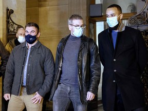 Anthony Sadler (right), Alek Skarlatos (left) and their lawyer Thibault de Montbrial leave the courthouse in Paris, on November 19, 2020, after appearing in the trial of Ayoub El Khazzani.