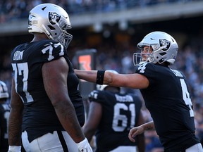 Derek Carr (right) of the Oakland Raiders celebrates with Trent Brown after scoring against the Cincinnati Bengals at RingCentral Coliseum on November 17, 2019 in Oakland.