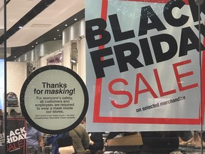 Signs scream masks and Black Friday sales at Fairview Mall in Toronto on Nov. 22, 2020, a day prior to the lockdown in Toronto and Peel regions.