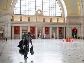 A man carries his bags through the main hall of Union Station in Washington, D.C., May 22, 2020.