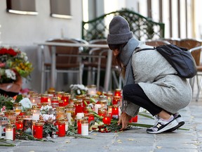 A woman places flowers at the site of a gun attack in Vienna, Austria, November 5, 2020.