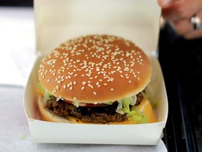 An employee prepares to serve a burger at a fast food restaurant in Nice, France, September 25, 2017.