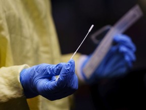 A nurse gets a swab ready to perform a test on a patient at a drive-in COVID-19 clinic in Montreal, on Wednesday, October 21, 2020.