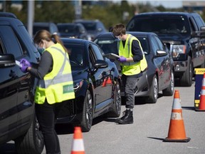 Paramedics register patients at a drive through, pop-up COVID-19 test centre outside the Canadian Tire Centre, in Ottawa, Sunday, Sept. 20, 2020.