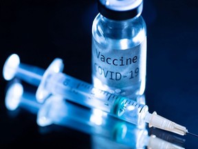 This picture taken on November 17, 2020 shows a syringe and a bottle reading "Vaccine Covid-19".