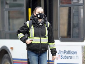 A woman wearing a face mask walks on Main Street in Winnipeg, Tuesday, Nov. 17, 2020.