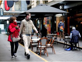 People walk past a cafe after the coronavirus disease (COVID-19) restrictions were eased for the state of Victoria, in Melbourne, Australia, October 28, 2020.
