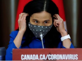 Canada's Chief Public Health Officer Dr. Theresa Tam puts on a mask at a news conference held to discuss the country's coronavirus disease (COVID-19) response in Ottawa, Ontario, Canada. November 6, 2020.