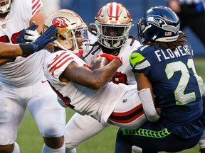 Seattle Seahawks cornerback Tre Flowers (21) tackles San Francisco 49ers wide receiver Kendrick Bourne (84) after a reception by Bourne during the fourth quarter at CenturyLink Field. San Francisco 49ers running back JaMycal Hasty (38, middle) reacts to the play.