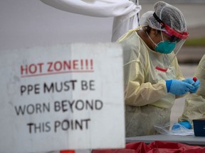 A health-care worker prepares specimen collection tubes at a coronavirus disease (COVID-19) drive-thru testing location in Houston, Texas, U.S., November 20, 2020.