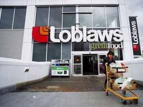 A woman carts out her groceries from a Loblaws grocery store in Toronto on May 1, 2014.
