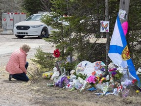 A woman pays her repects at a roadblock in Portapique, N.S. on Wednesday, April 22, 2020.