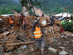 Soldiers remove debris and mud from an area hit by a mudslide, caused by heavy rains brought by Storm Eta, as the search for victims continue in the buried village of Queja, Alta Verapaz, Guatemala November 7, 2020.