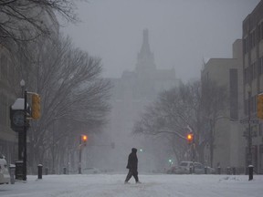 A pedestrian walks through the downtown area during a snowstorm in Saskatoon on Sunday, November 8, 2020.