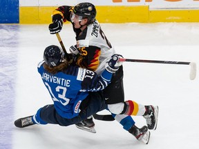 Roby Jarventie (No. 13) of Finland collides with Mario Zimmermann (No. 25) of Germany during the 2021 IIHF World Junior Championship at Rogers Place on December 25, 2020 at Rogers Place.