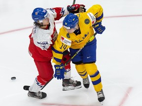 Arvid Costmar (No. 14) of Sweden battles against Filip Koffer (No. 27) of the Czech Republic during the 2021 IIHF World Junior Championship at Rogers Place on December 26, 2020.