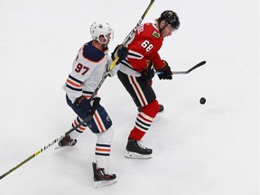 Slater Koekkoek #68 of the Chicago Blackhawks is pursued by Connor McDavid #97 of the Edmonton Oilers during the first period in Game 3 of the Western Conference Qualification Round at Rogers Place on August 05, 2020.