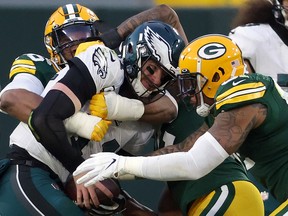 Carson Wentz #11 of the Philadelphia Eagles is sacked by Kingsley Keke #96 and Preston Smith #91 of the Green Bay Packers on Sunday. Wentz was benched in the Packers' win.