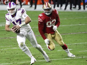 Quarterback Josh Allen, left, of the Buffalo Bills scrambles ahead of defender defensive end Kerry Hyder of the San Francisco 49ers during the second quarter of a game at State Farm Stadium on Dec. 7, 2020 in Glendale, Ariz.